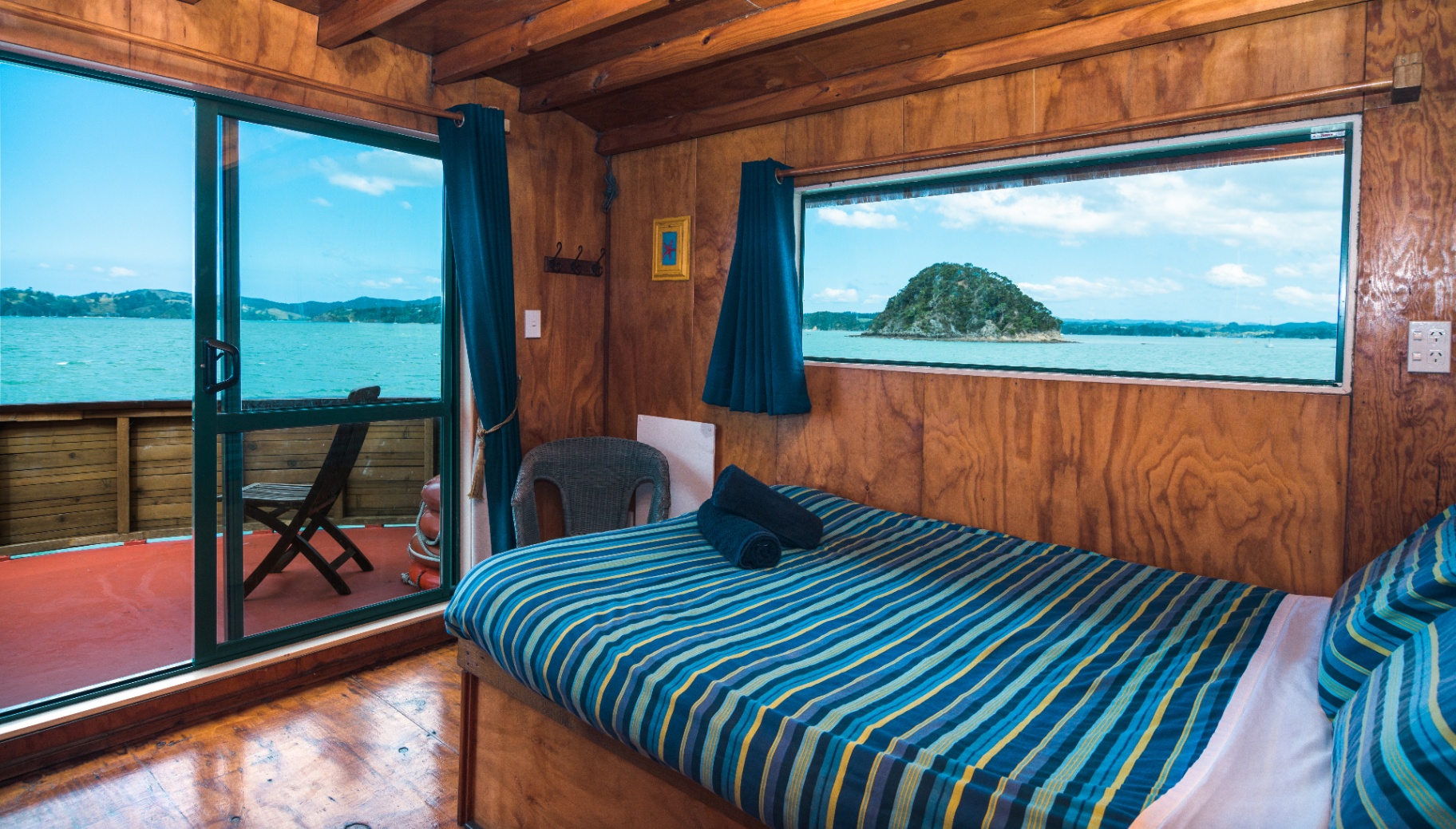 Double cabin onboard The Rock with a double bed, balcony and Bay of Islands view